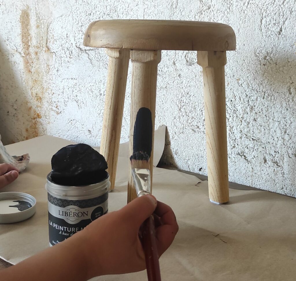 Image d'une main en train de repeindre un meuble de l'Astucerie à Livron-sur-Drôme.