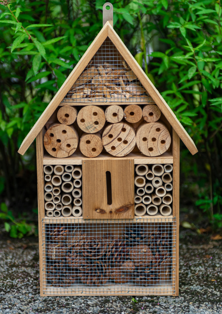 Image d'un hôtel à insectes en bois et matériaux naturels.