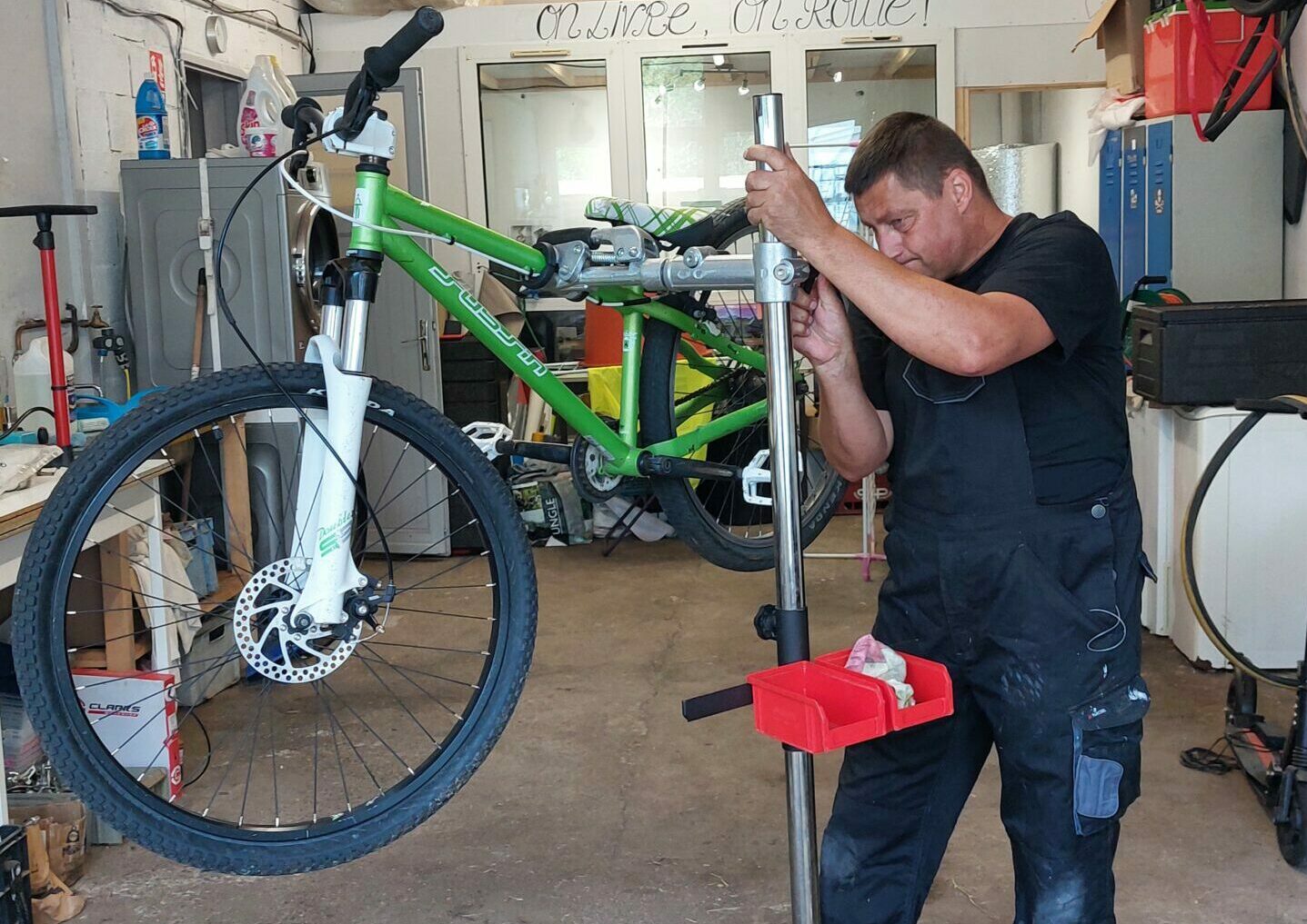 Photo d'un homme qui répare un vélo.