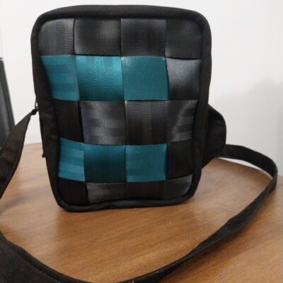 Ravissante sacoche en ceintures de sécurité vertes Photo d'une petite sacoche pour homme en ceintures de sécurité; Elles est noir et vert et façonnèe par les couturières de Livron-sur-Drôme, Les Mains d'Or.