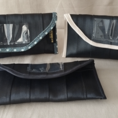 Enveloppes réutilisables, utiles et élégantes Photo de trois petites enveloppes cousues à partir de ceintures de sécurité à l'atelier de couture de Val d'Emploi.