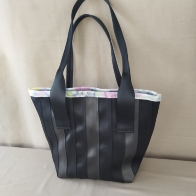 Sac à main aux finitions fleuries Photo d'un sac pour femme cousu par Les Mains d'Or, l'atelier couture de Livron-sur-Drôme. Il est fait en cientures de sécurité fournies par l'entreprise de recyclage automobile GPA