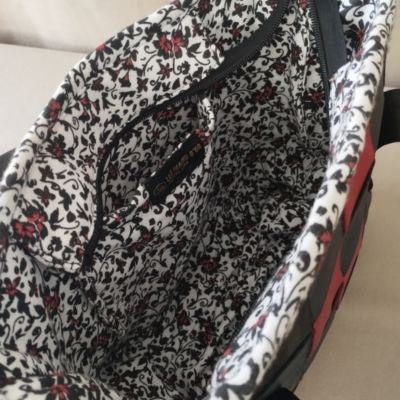 Élégant sac à bandoulière, intérieur floral Photo de l'intérieur d'un sac en ceintures de sécurité. Le tissus est fleuri et est issu du recyclage textile de Livron-sur-Drôme.