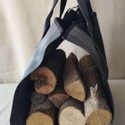 Tapis à bûches, costaud et pratique Photo d'un sac à bûches cousu par l'atelier couture de Livron-sur-Drôme. La matière première utilisée sont des ceintures de sécurité automobile.