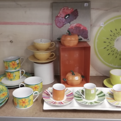 Photo du rayon vaisselle d'occasion, présentant des pièces colorées pour l'été.